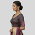 Woman wearing a traditional saree with a plain background