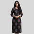 Woman wearing a black dress with red and blue circular patterns on a gray background