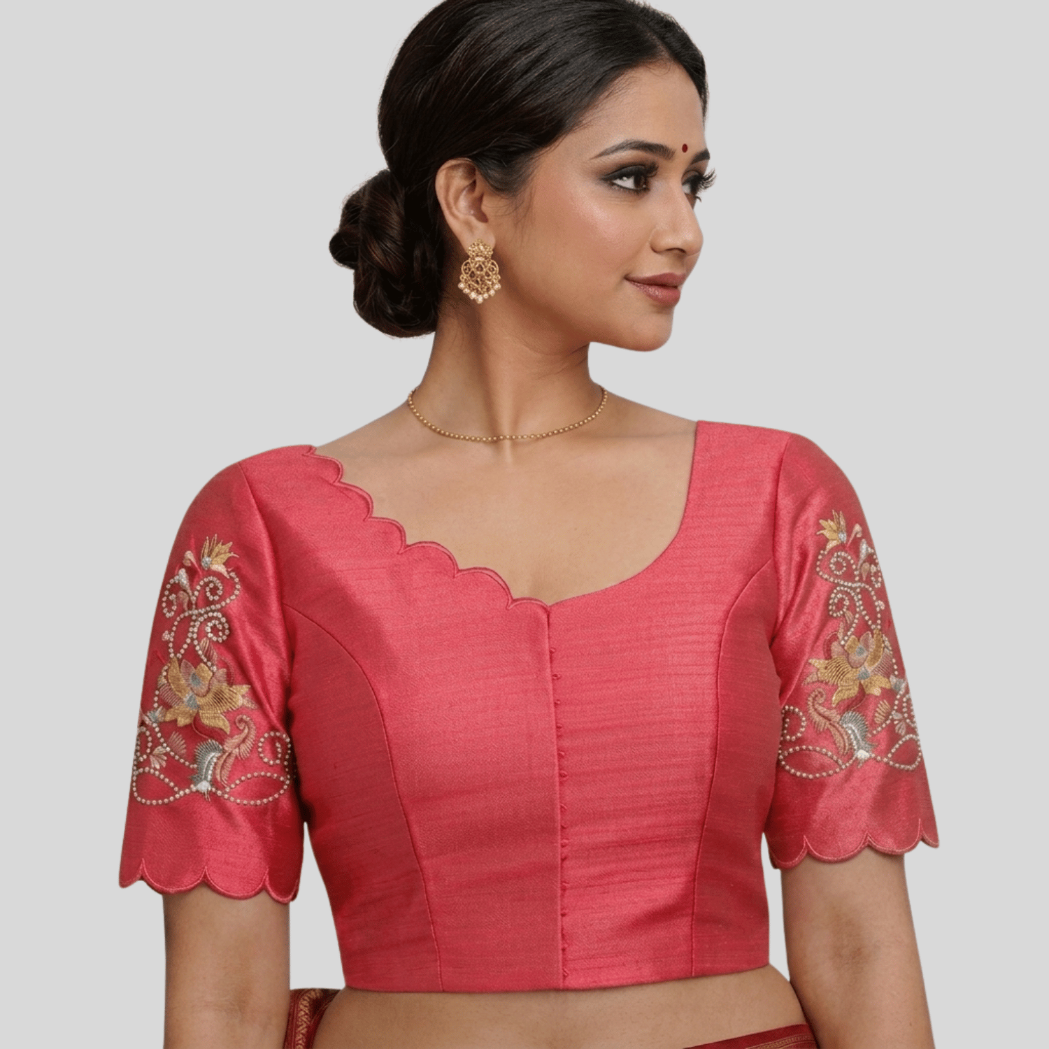 Woman wearing a pink blouse with intricate designs with Scallop embroidery